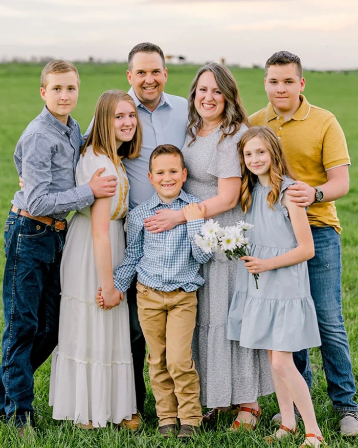The family behind Simply Daisy, standing together in a pasture